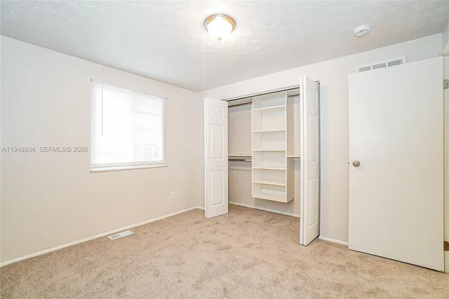 a view of an empty room with a closet