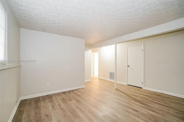 a view of an empty room with wooden floor
