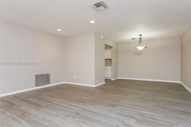 a view of empty room with wooden floor