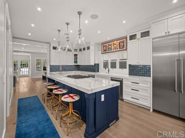 a kitchen with kitchen island a counter top space a sink stainless steel appliances and cabinets