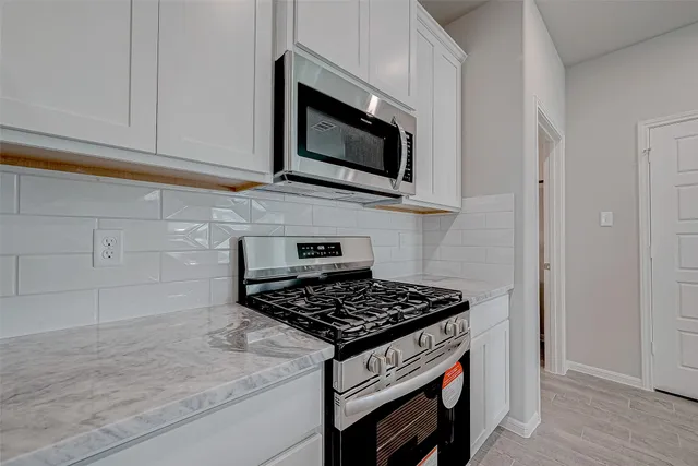a kitchen with stainless steel appliances a stove and a microwave
