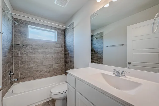 a bathroom with a bathtub shower sink mirror vanity and toilet