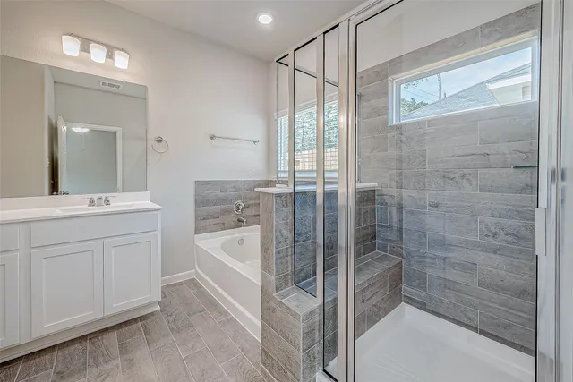 a spacious bathroom with a shower a sink and a mirror