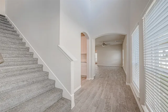 a view of a hallway with wooden floor and staircase