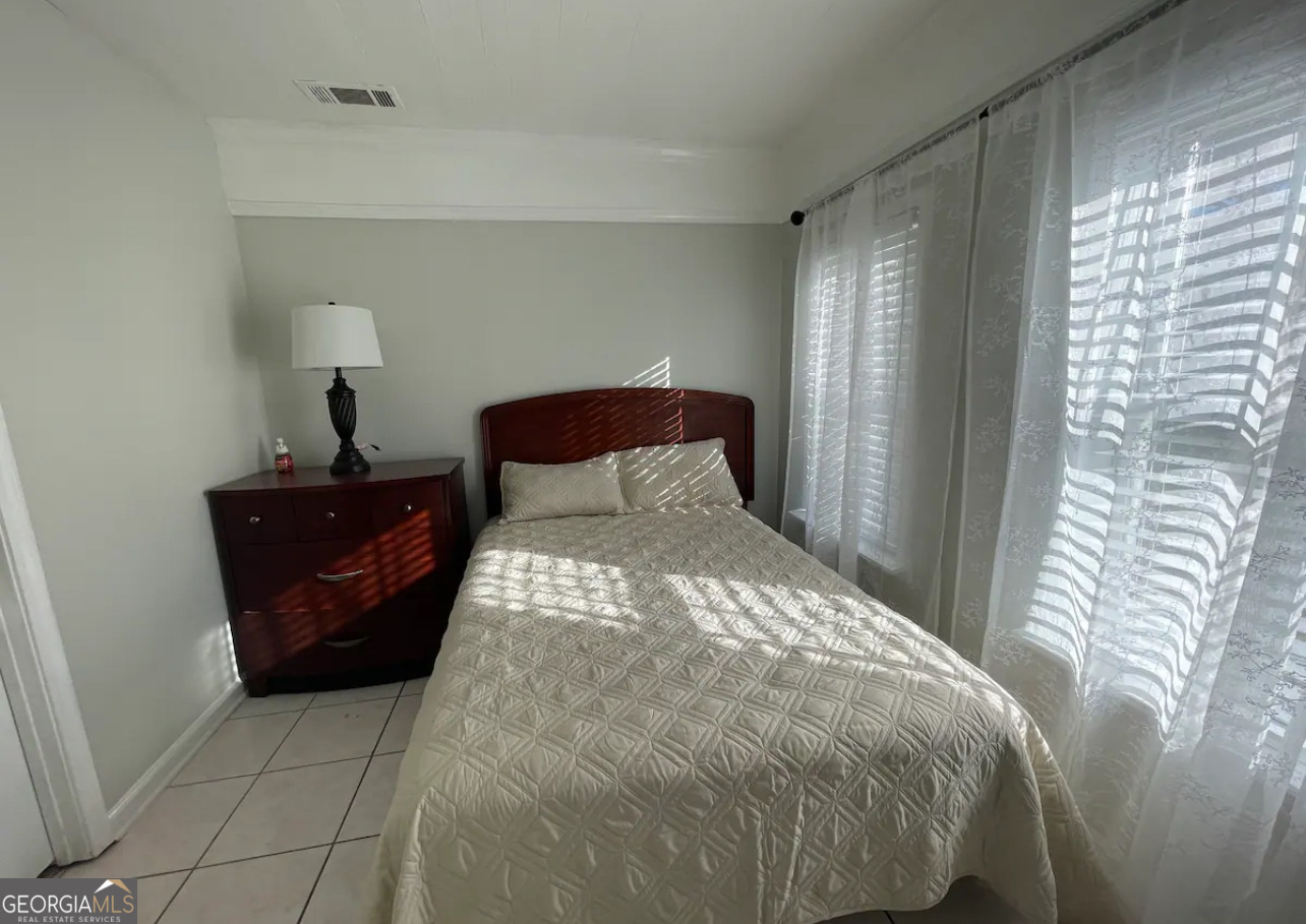 1401 Panola Road Stone Mountain, GA 30088 - Photo 9 of 15 a bedroom with a bed and window