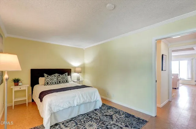 a bedroom with a bed and a lamp with wooden floor