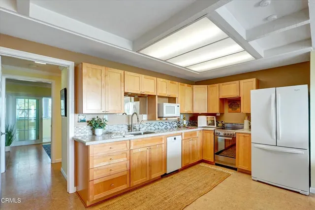 a kitchen with a sink refrigerator and cabinets