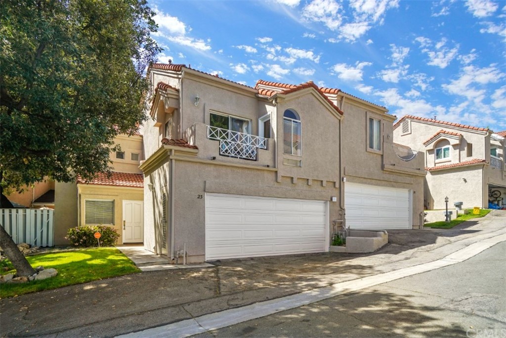 a view of a white house with large windows and a small yard
