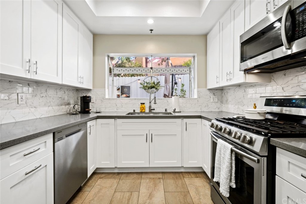 6255 Honolulu Avenue, Unit 23 Tujunga, CA 91042 - Photo 12 of 36 a kitchen with stainless steel appliances a stove a sink and a microwave