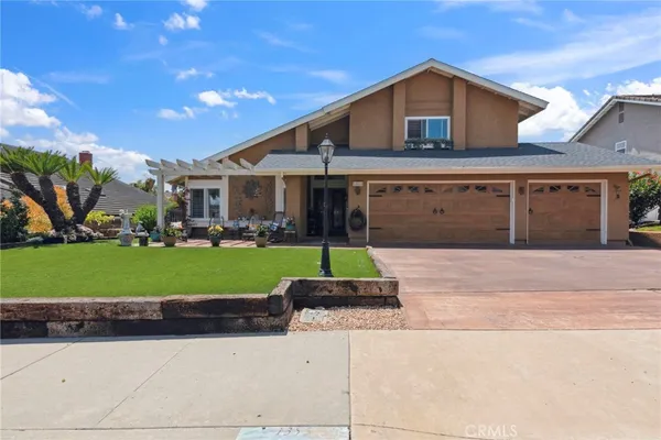 a front view of a house with a garden and plants