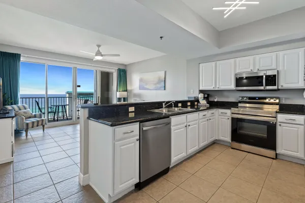 a kitchen with stainless steel appliances granite countertop a stove top oven a sink a counter top space and cabinets
