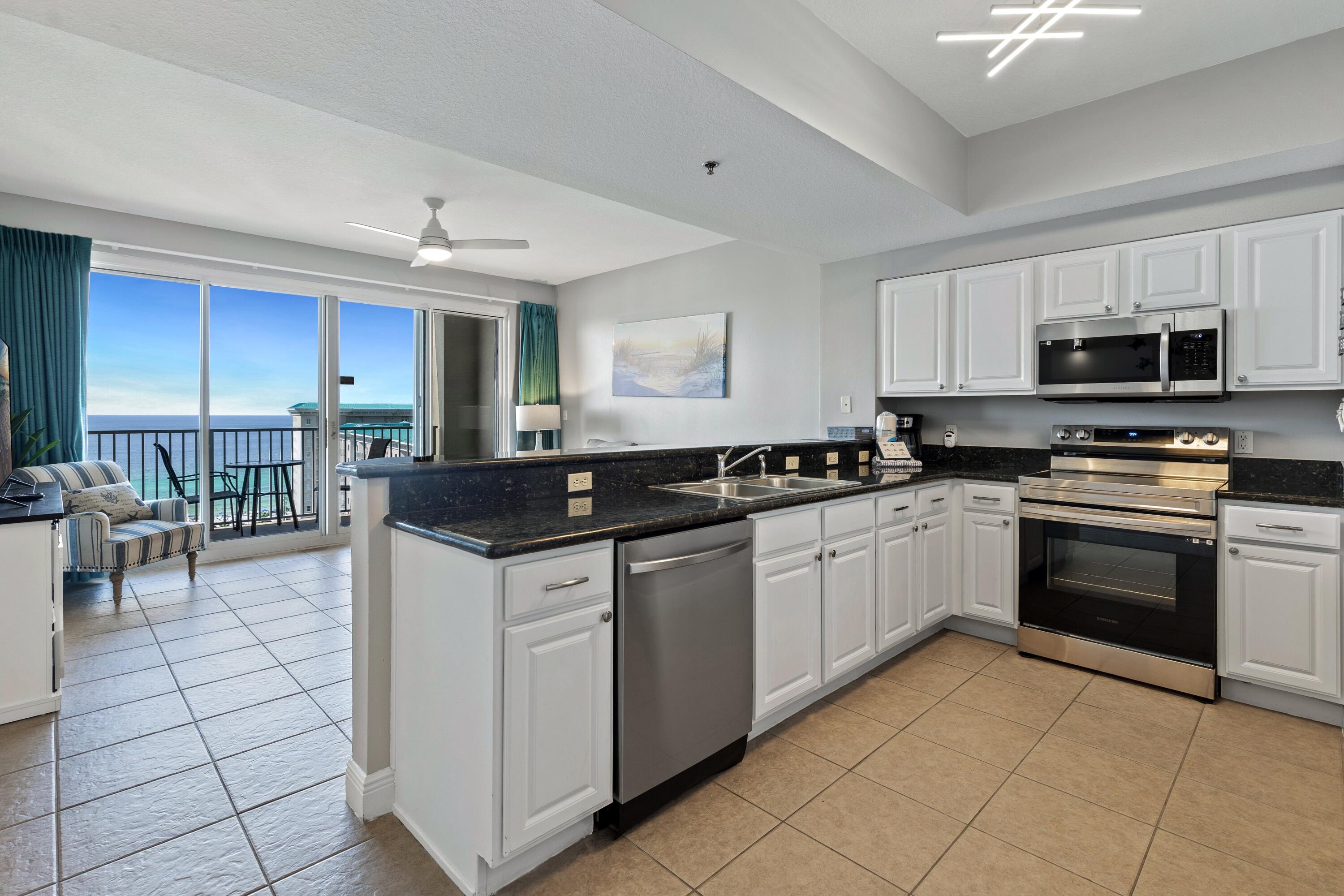 112 Seascape Drive, Unit 1306 Miramar Beach, FL 32550 - Photo 3 of 28 a kitchen with stainless steel appliances granite countertop a stove top oven a sink a counter top space and cabinets
