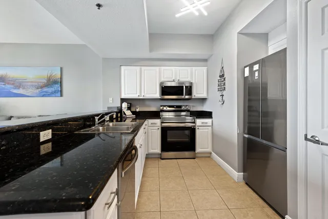 a kitchen with kitchen island granite countertop a stove sink and refrigerator