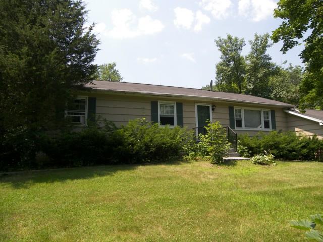 a front view of house with yard and green space