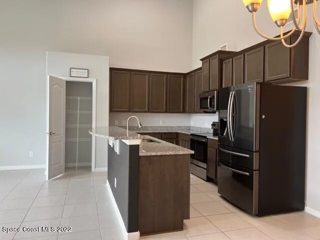 a kitchen with stainless steel appliances granite countertop a refrigerator and a stove top oven