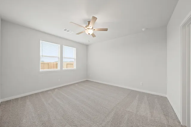 an empty room with windows and fan