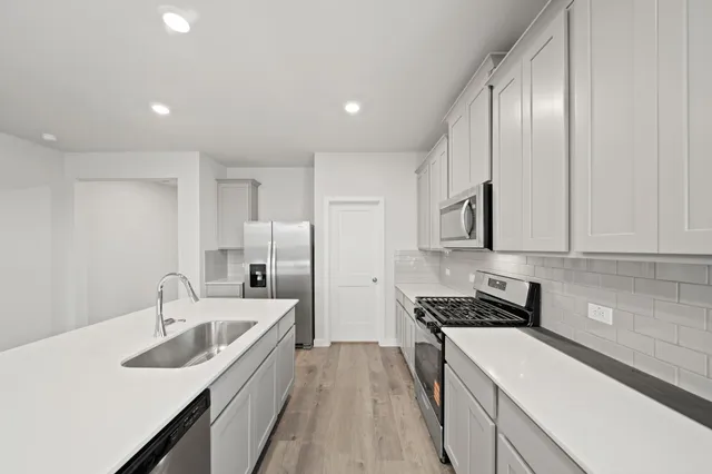 a kitchen with stainless steel appliances granite countertop a sink stove and refrigerator
