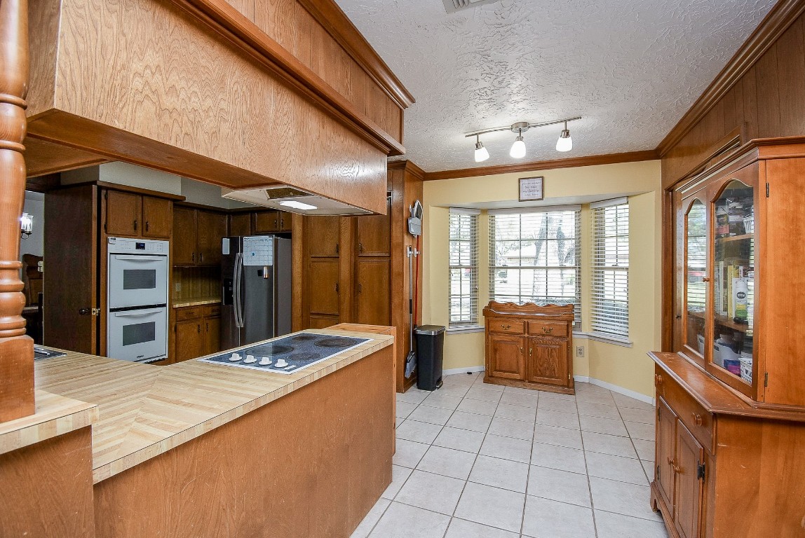 2719 Vail Road Rosenberg, TX 77471 - Photo 19 of 37 a large kitchen with kitchen island granite countertop a large counter top stainless steel appliances a sink and living room view