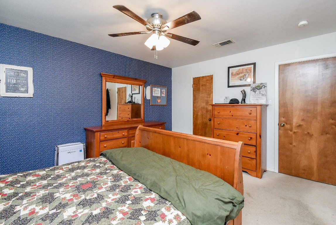 2719 Vail Road Rosenberg, TX 77471 - Photo 34 of 37 a bedroom with a bed and dresser with wooden floor