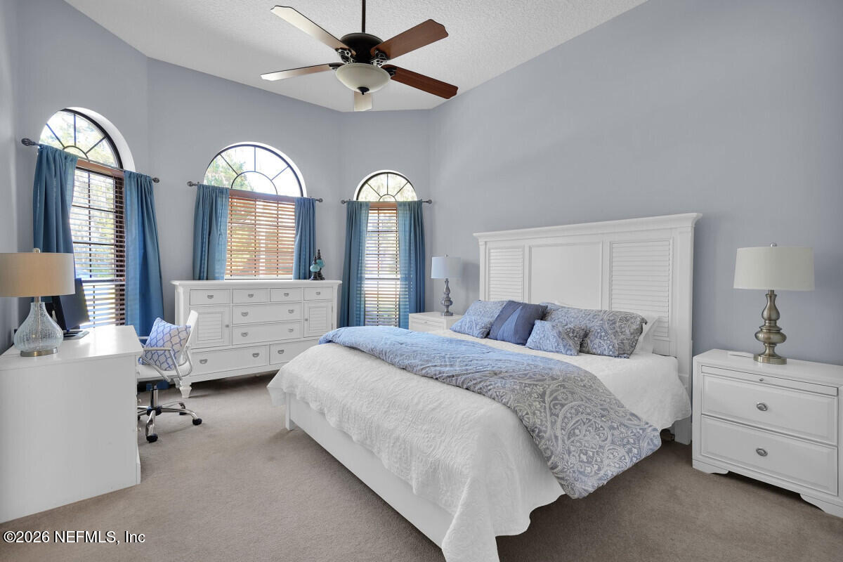 2942 Magnolia Road Orange Park, FL 32065 - Photo 28 of 50 a spacious bedroom with a bed and a chandelier