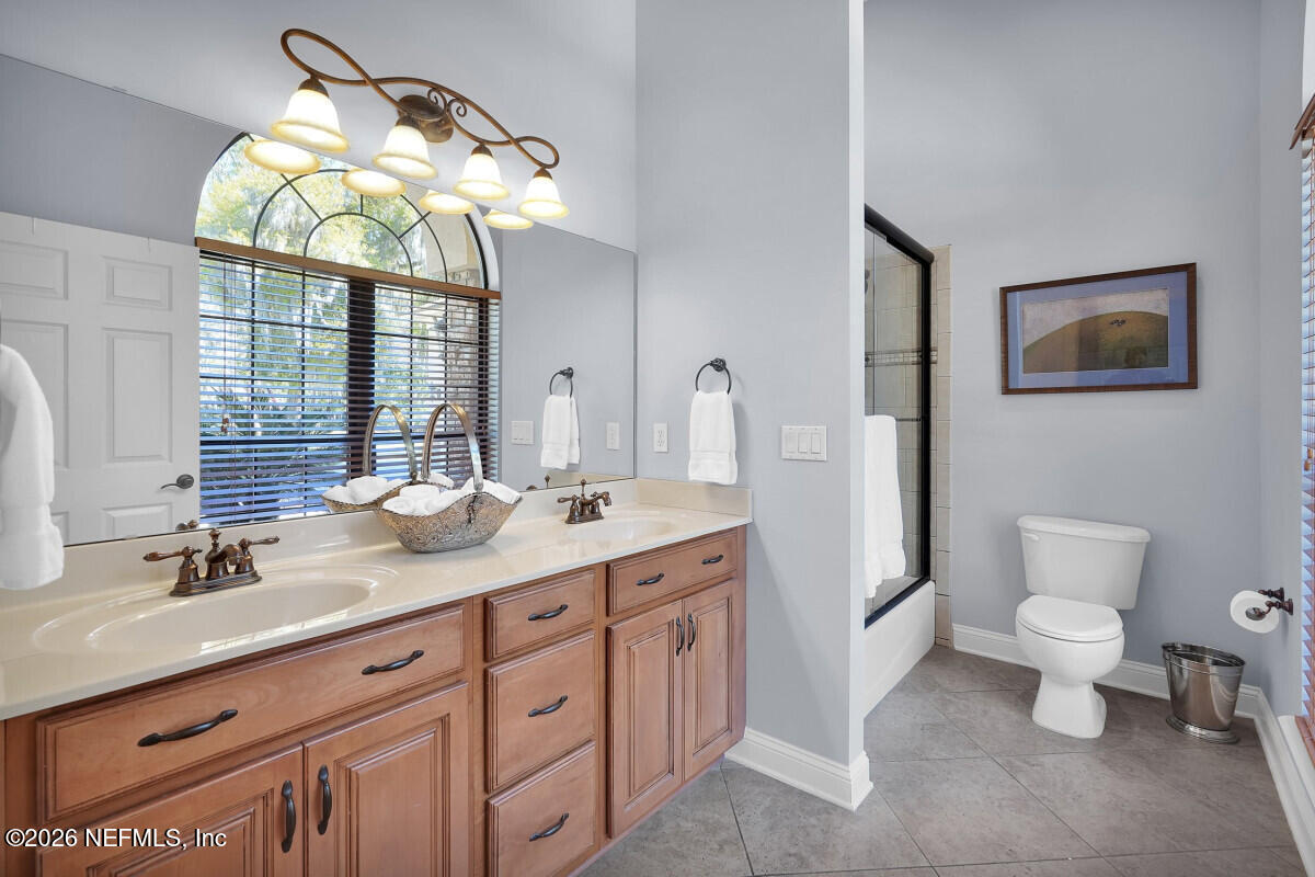 2942 Magnolia Road Orange Park, FL 32065 - Photo 30 of 50 a bathroom with a toilet a sink and mirror