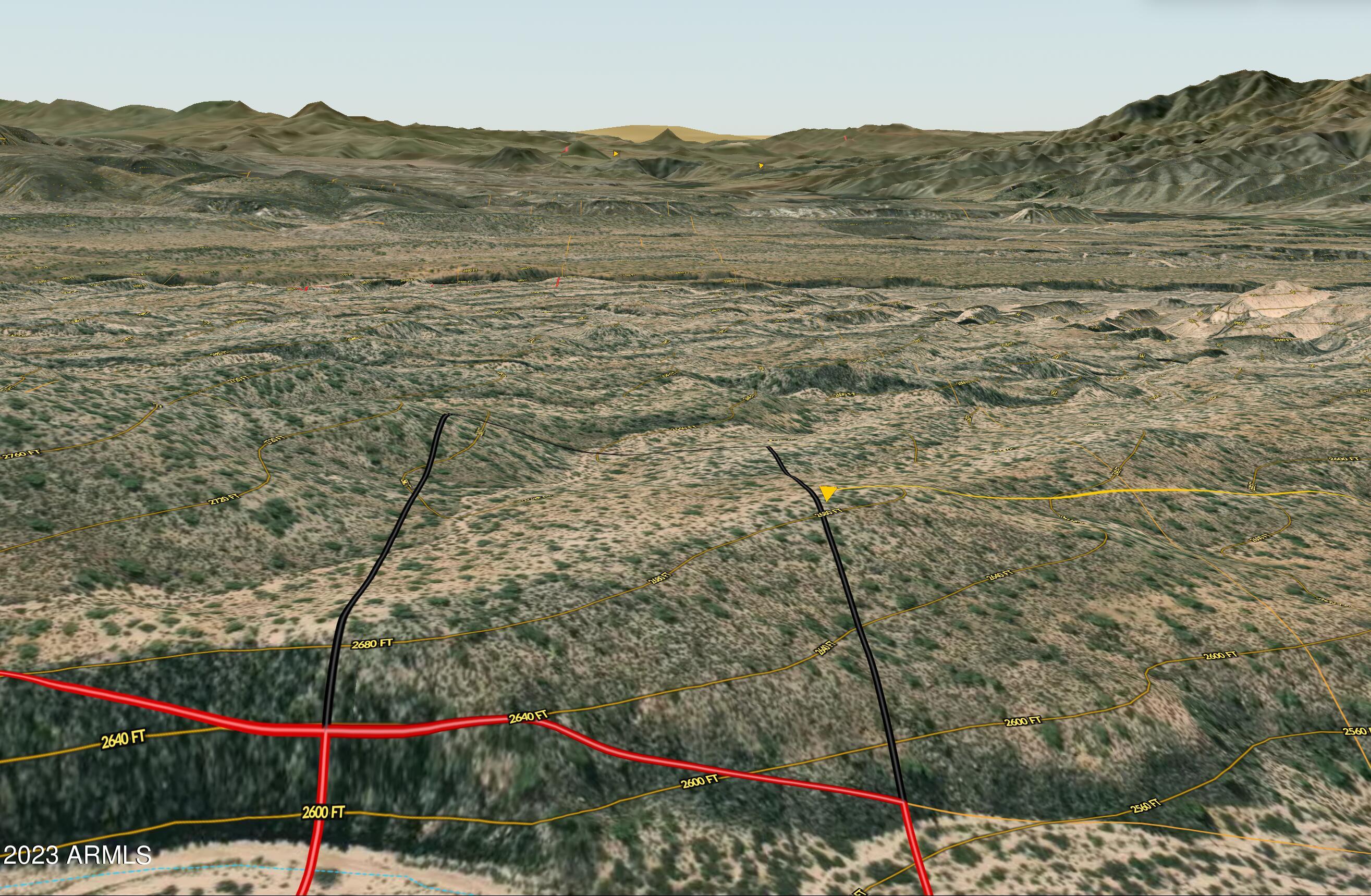 a view of a dry yard with wooden fence