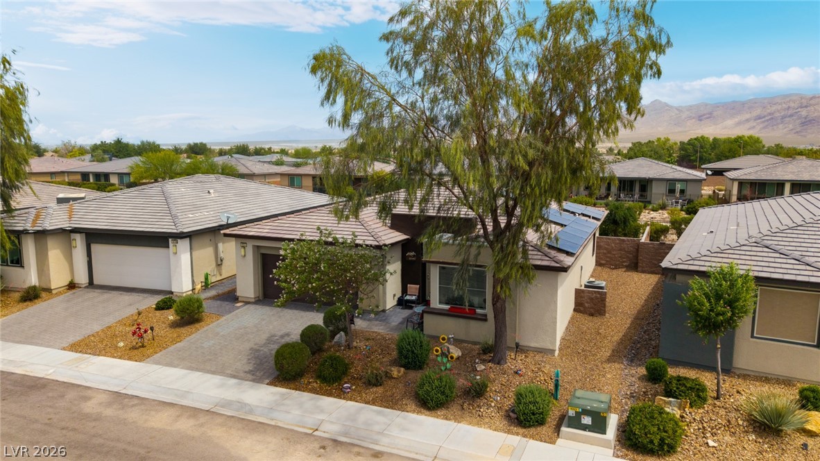 4914 East Beacon Ridge Drive Pahrump, NV 89061 - Photo 31 of 34 A welcoming front exterior features a paved driveway and low-maintenance landscaping, framed by distant mountains.
