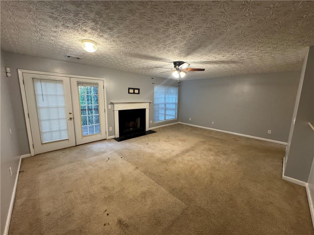 3653 Woodland Cove Decatur, GA 30034 - Photo 7 of 19 an empty room with fireplace fan and windows