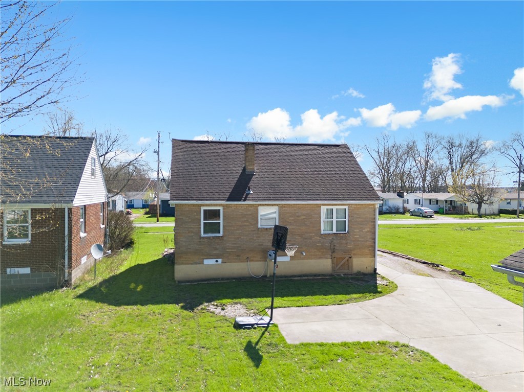 123 North Seneca Street Rittman, OH 44270 - Photo 23 of 32 Back of house with brick siding, a yard, and roof with shingles