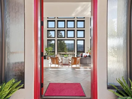 a living room with furniture a fireplace and a floor to ceiling window