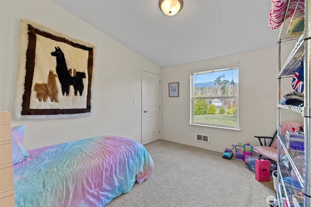 a bedroom with a bed and painting on the wall