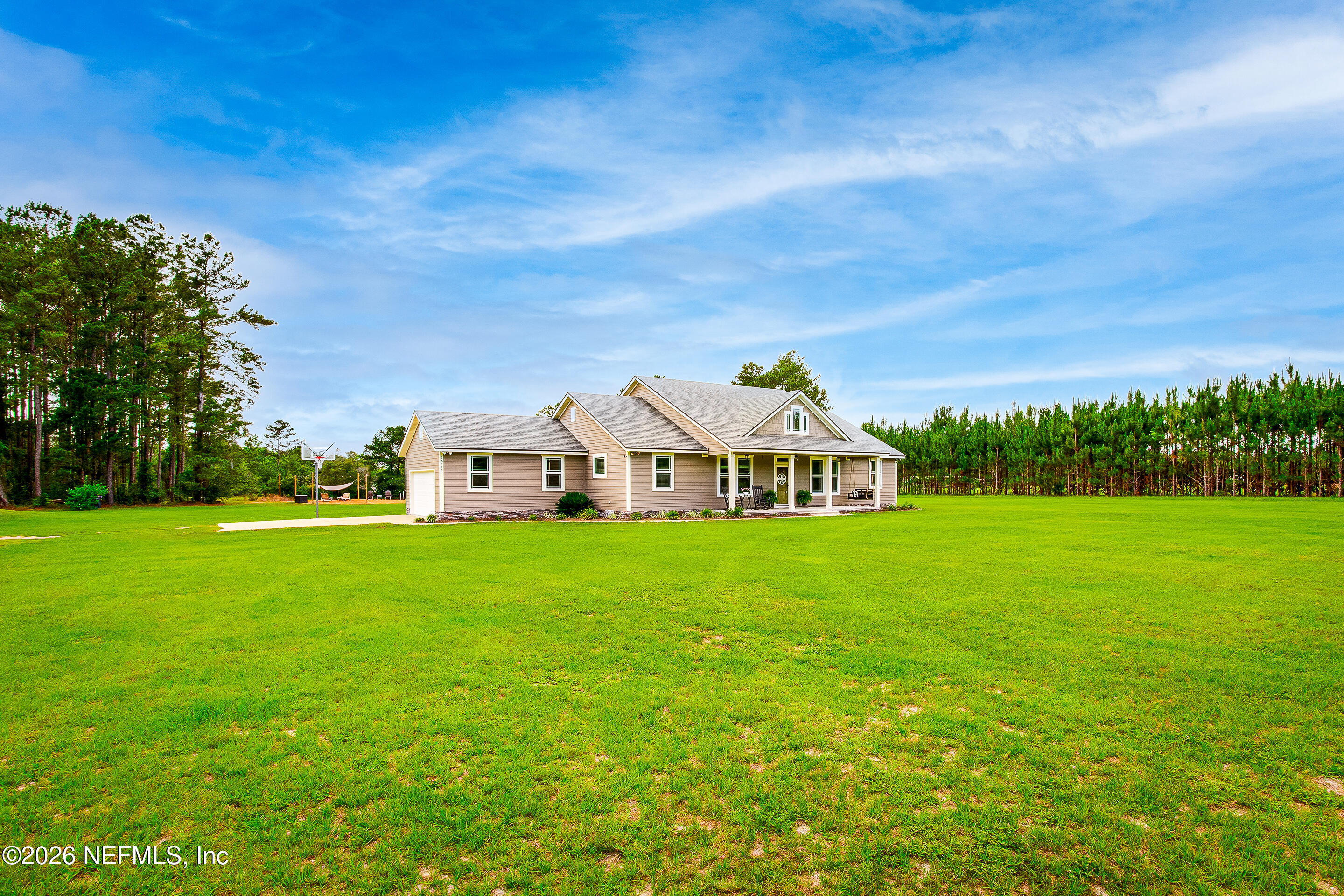 26575 Sheared Stokes Road Hilliard, FL 32046 - Photo 3 of 39 a view of a big house with a big yard and large trees