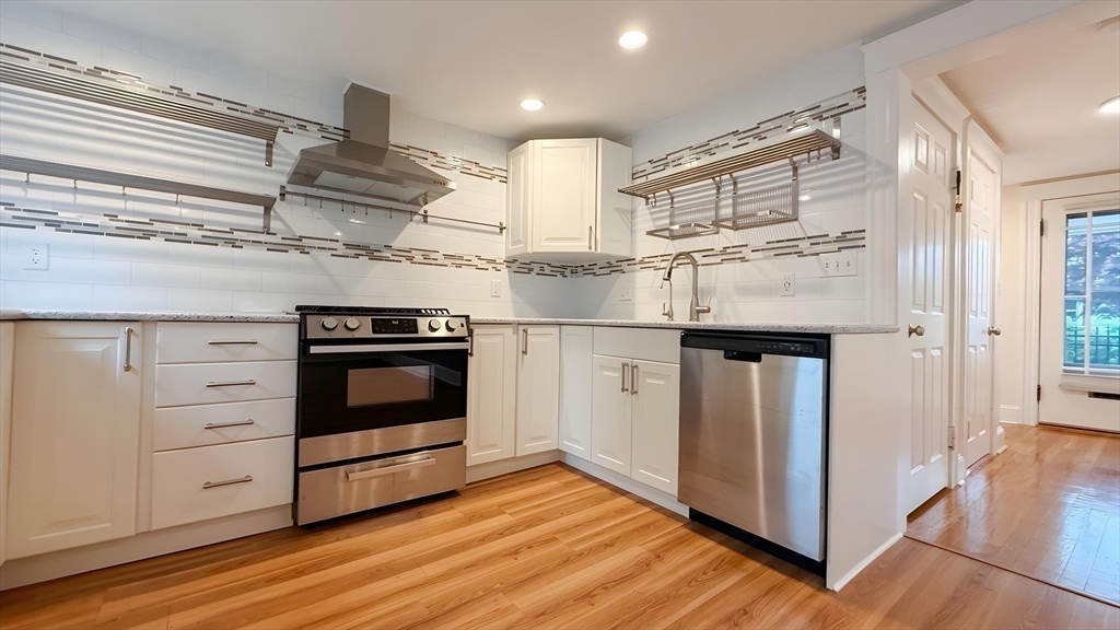 114 Curve Street Dedham, MA 02026 - Photo 7 of 27 a kitchen with stainless steel appliances granite countertop a stove and a refrigerator