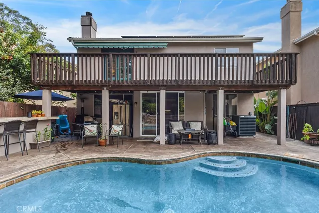 a front view of a house with swimming pool table and chairs
