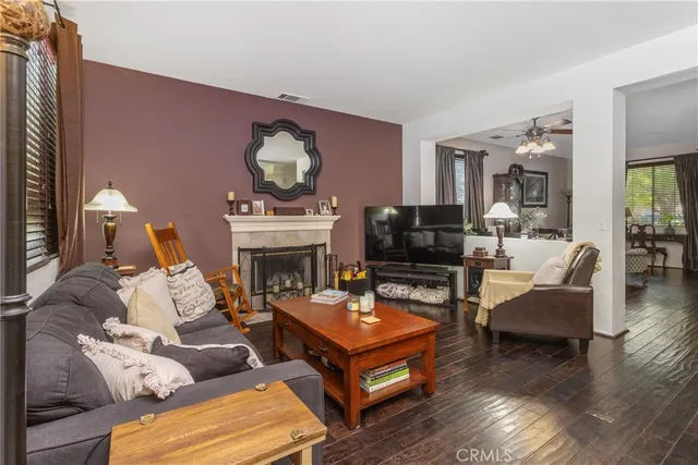 a living room with furniture a fireplace and a large mirror with wooden floor
