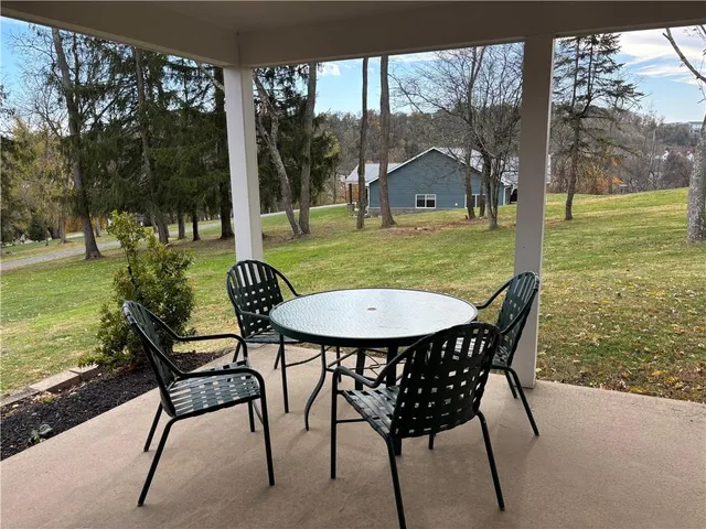 a view of a chairs and table in patio with a yard
