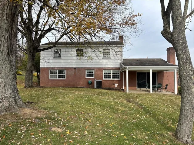 a view of a yard in front of a house with large tree