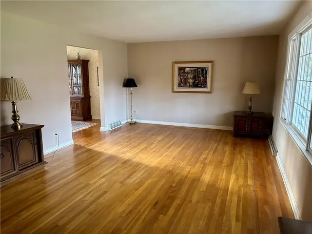 a view of a room with wooden floor and furniture
