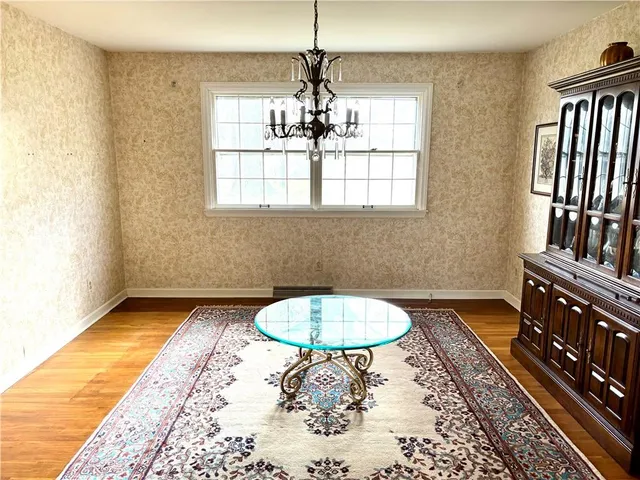 a view of a room with a chandelier and wooden floor