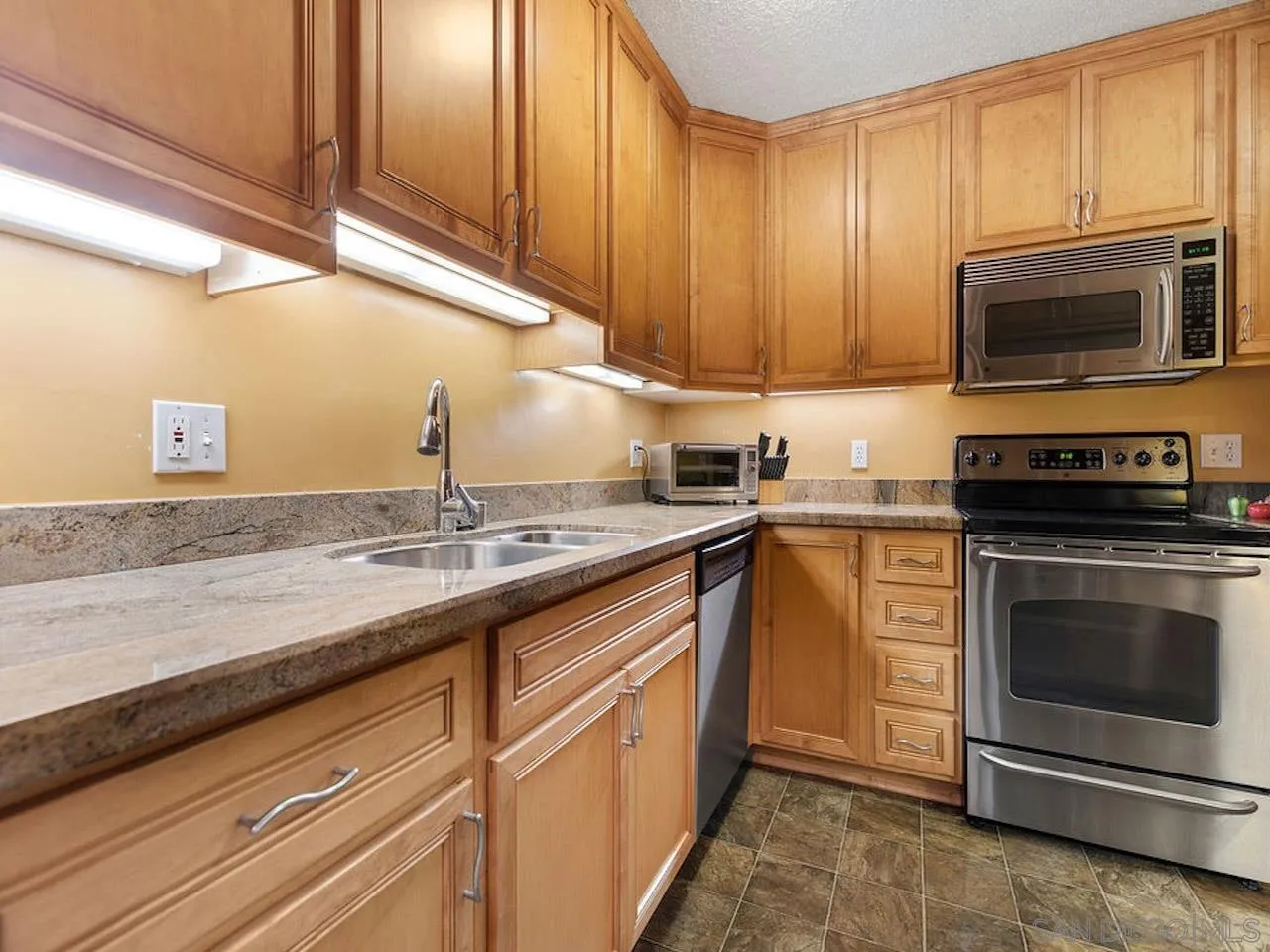 800 Prospect Street, Unit 4A La Jolla, CA 92037 - Photo 22 of 34 a kitchen with granite countertop a sink stainless steel appliances and cabinets