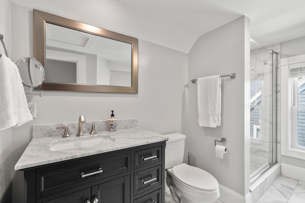 103 Belgrade Avenue, Unit 2 Boston, MA 02131 - Photo 14 of 24 a bathroom with a granite countertop toilet sink and mirror