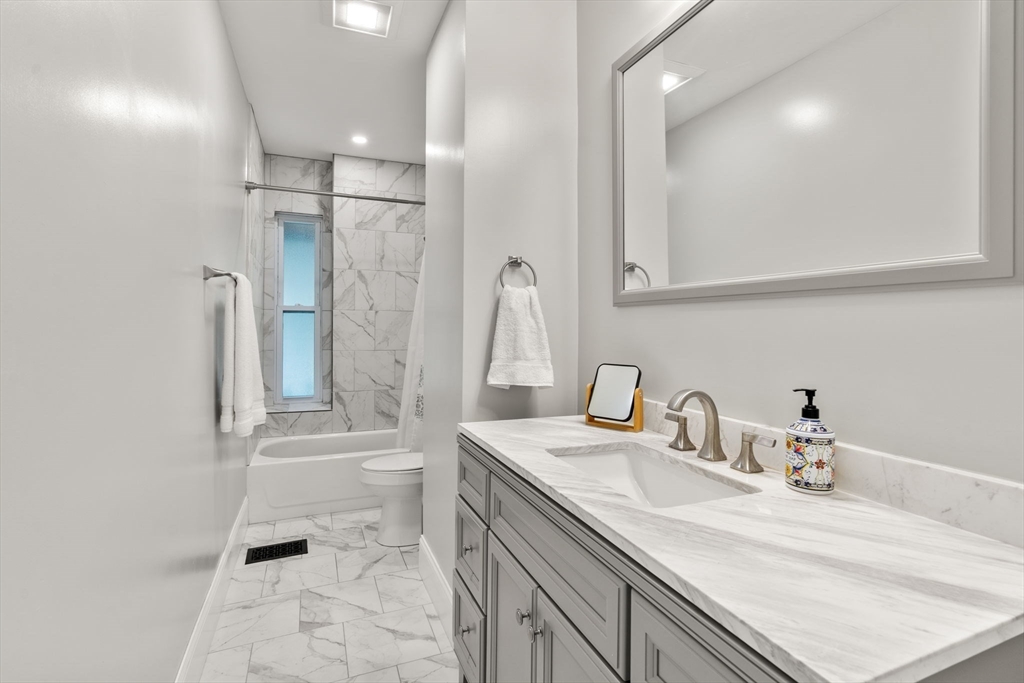 103 Belgrade Avenue, Unit 2 Boston, MA 02131 - Photo 8 of 24 a bathroom with a sink a toilet and shower