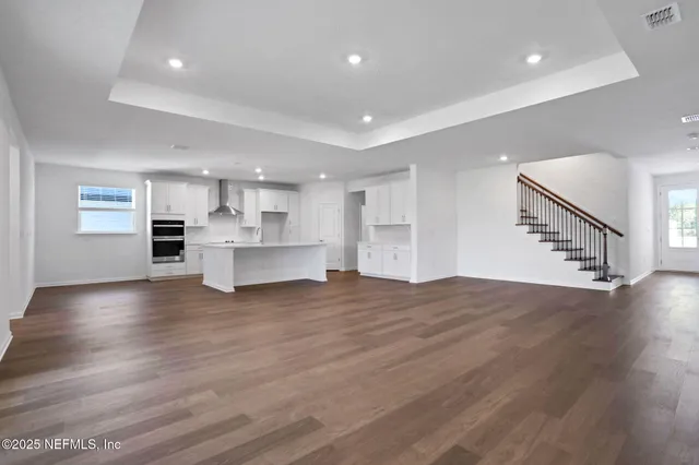 a view of kitchen and hall with wooden floor