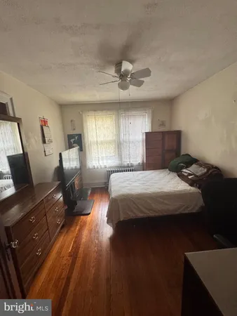 a bedroom with a bed a couch and dresser