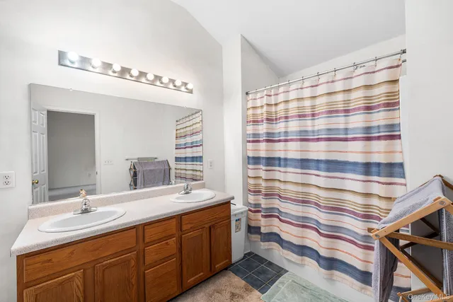 a bathroom with double vanity and a mirror