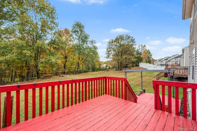 a balcony with wooden floor and yard in the back