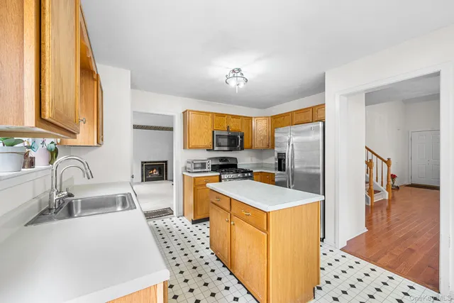 a kitchen with stainless steel appliances a refrigerator a sink a stove and white cabinets