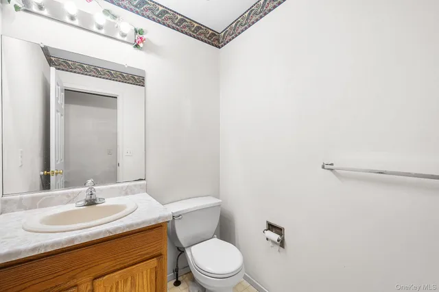a bathroom with a sink vanity mirror and toilet