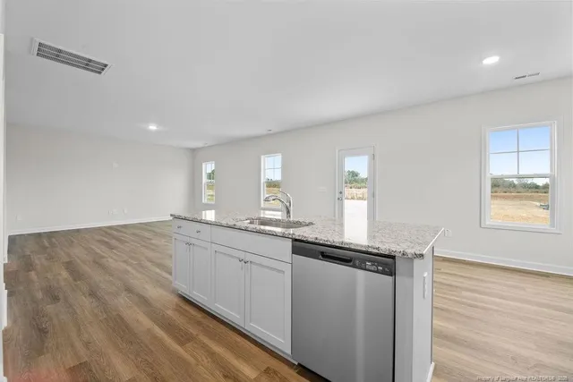 a kitchen with granite countertop a sink and cabinets
