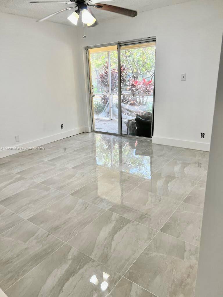 5720 Rock Island Road, Unit 385 Tamarac, FL 33319 - Photo 2 of 9 an empty room with windows and city view
